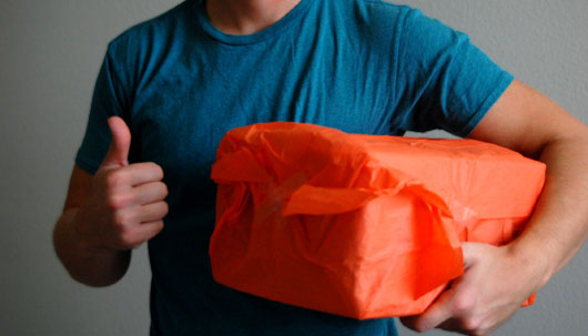 Gift wrapping A man holding a terribly wrapped present