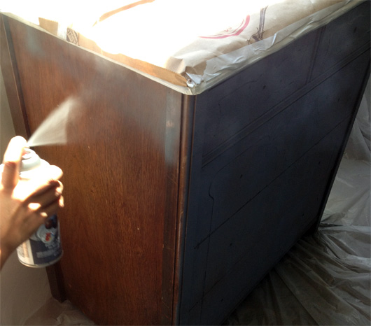 spray paint furniture An old dresser being spray painted