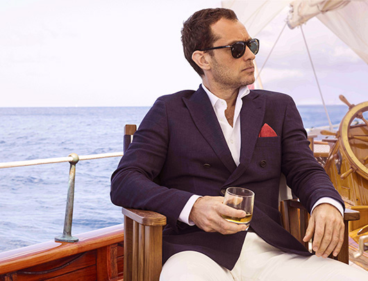 Jude Law sitting next to a body of water