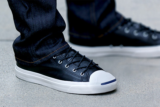 A pair of feet wearing black leather shoes