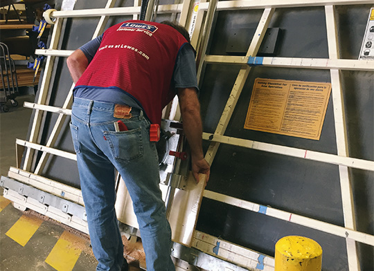 A Lowes employee cutting wood