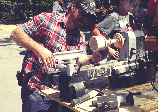 A group of people using a lathe