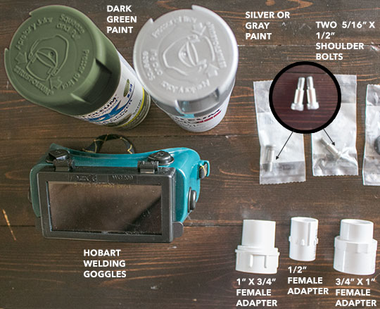 parts to create ecto goggles for DIY Ghostbuster costume including dark green spray paint, silver or grey spray paint, Hobart welding goggles, two 5/16 x 1/2" shoulder bolts, 1" x 3/4" female adapter, 1/2" female adapter, 3/4" x 1" female adapter