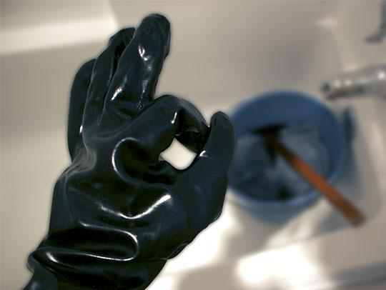 using chemical gloves to mix gray garment dye in a bucket for DIY Ghostbuster costume