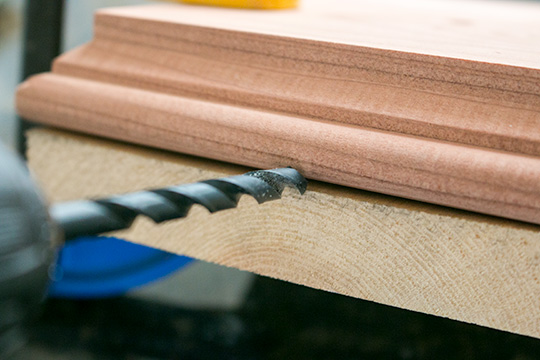 A drill bit going into wood