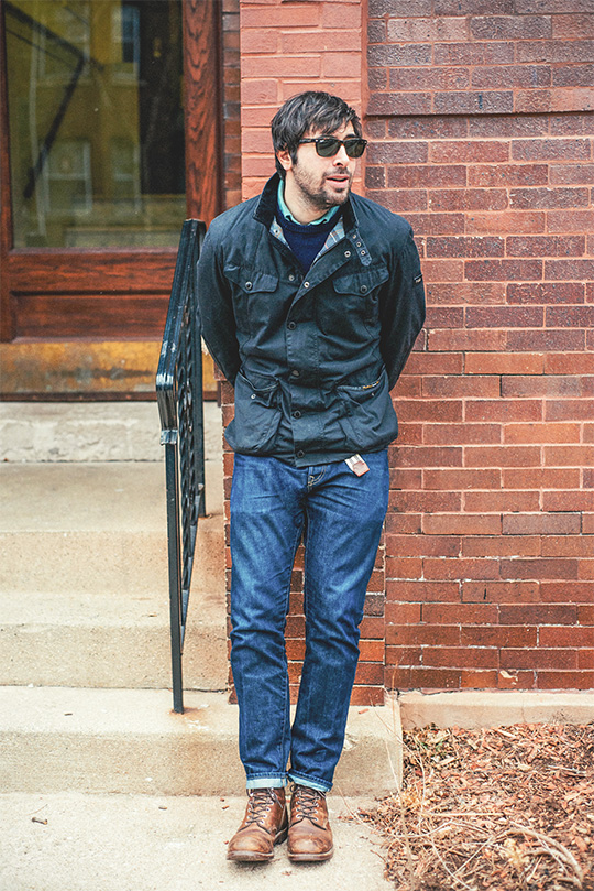 man wearing black Moto jacket with jeans and red wing iron rangers