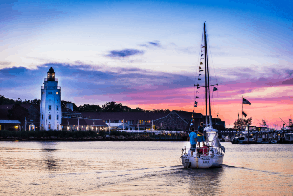 A sloop sails in to Montauk harbor