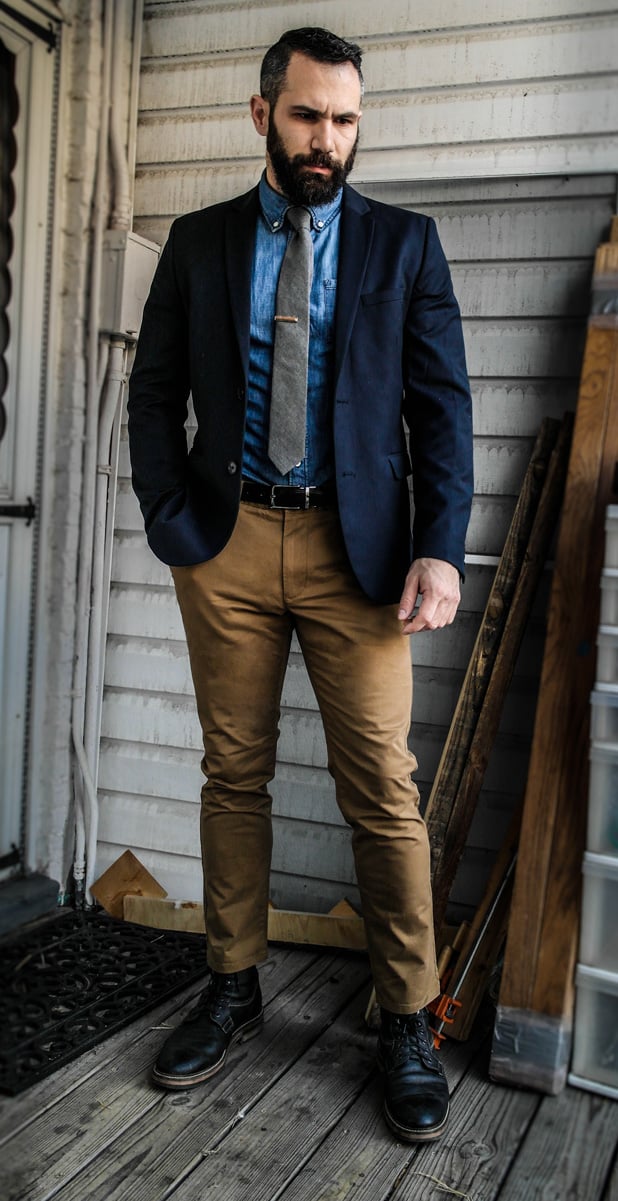 A man in a suit jakcet standing in front of a building