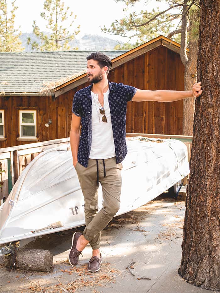 A man standing in front of a house with khaki jogger pants