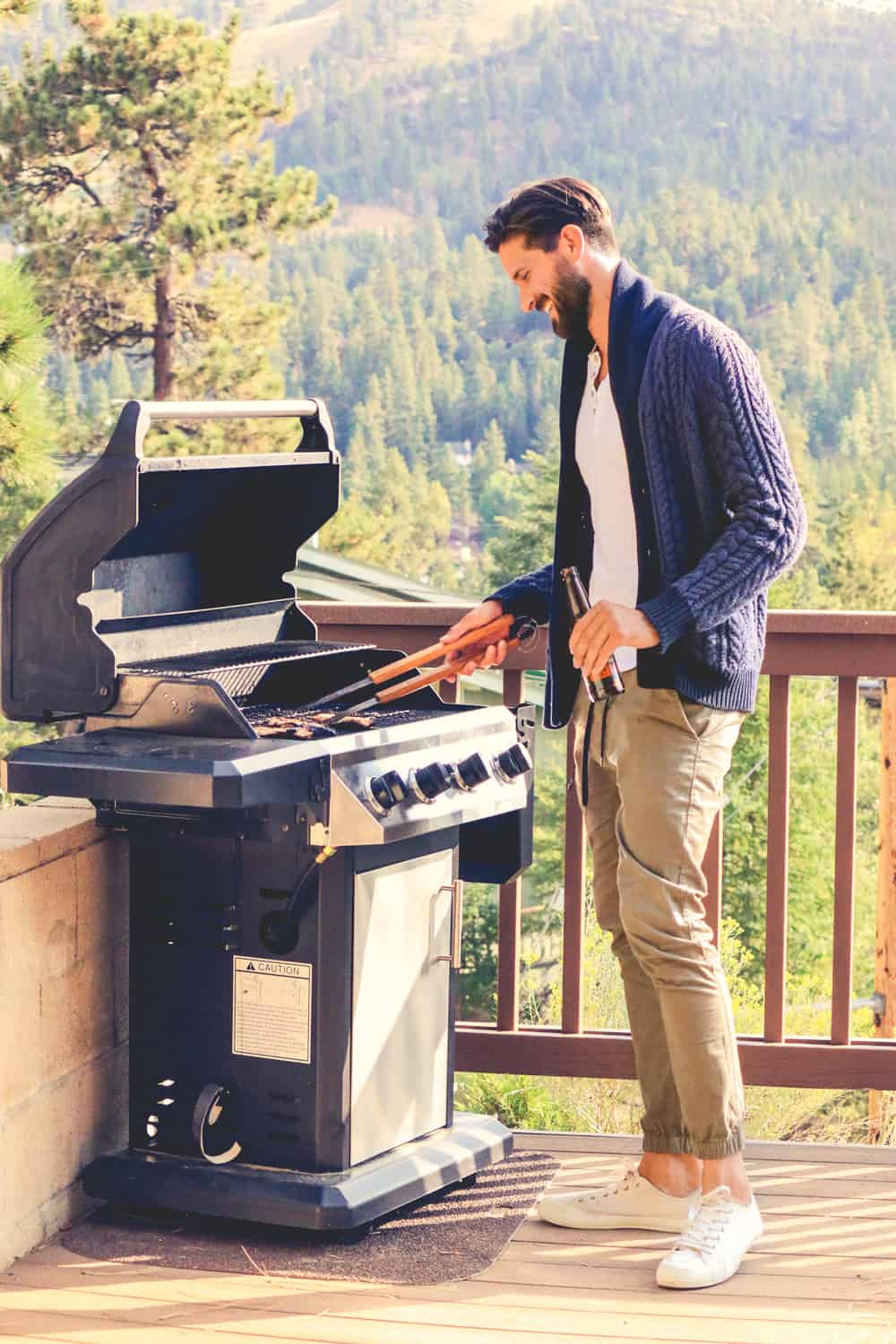A man standing in front of a grill wearing khaki pants