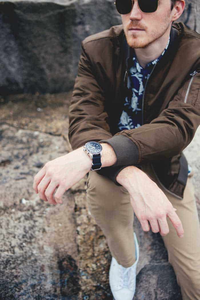 A person sitting on the ground showing a watch