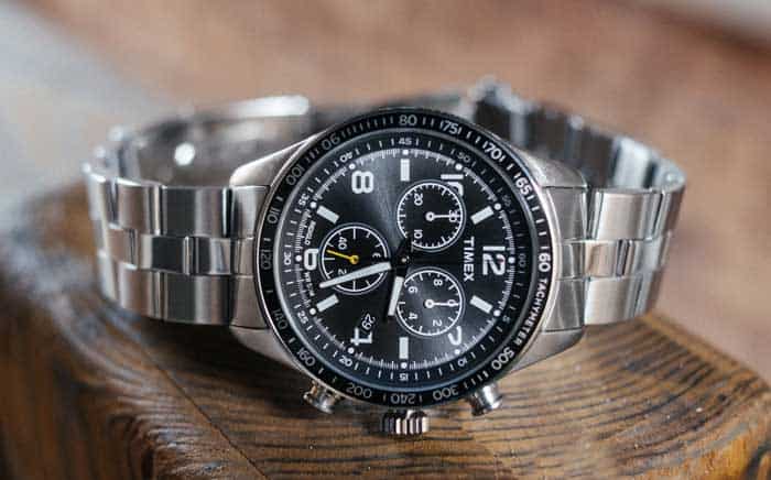 A watch sitting on top of a wooden table