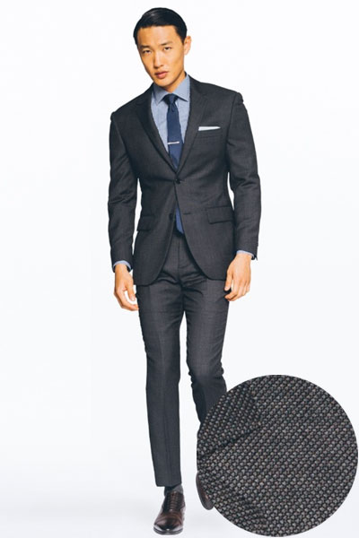 A man wearing a charcoal suit and tie