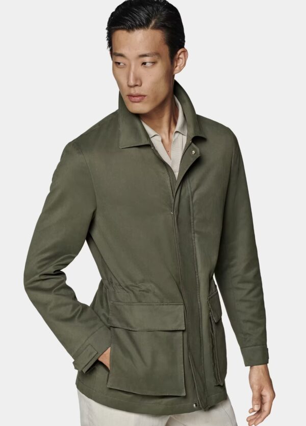 a man wearing a dark green water repellant field jacket