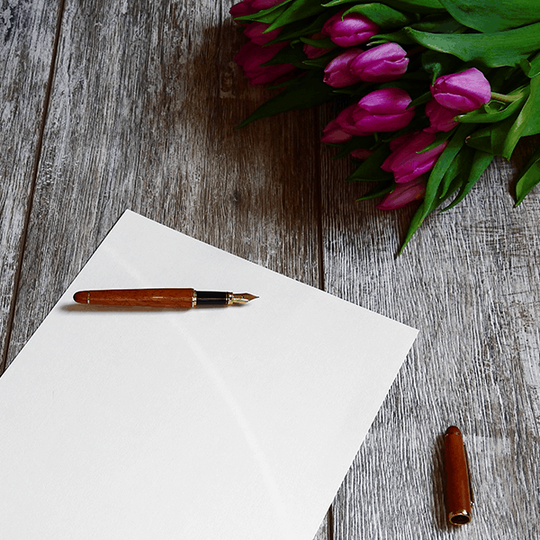 msgflower Paper and pen on table with flowers