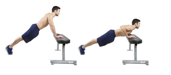 Image of man doing pushup exercises on a gym bench