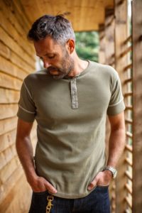 man wearing green short sleeve henley style shirt