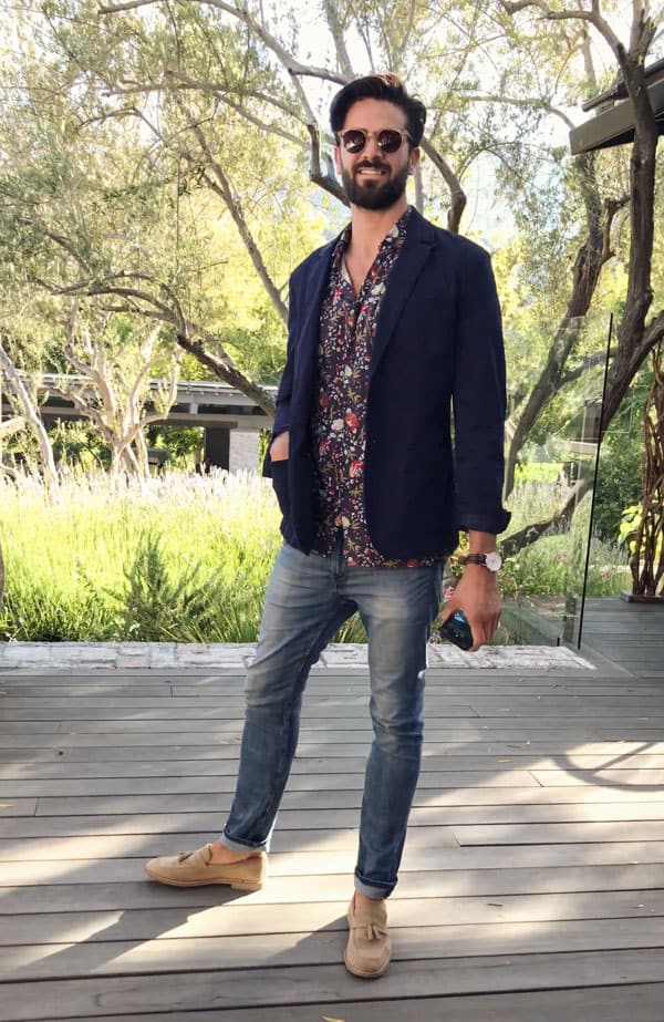 A man wearing a floral shirt with navy blazer