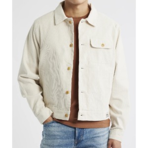 man wearing a cotton corduroy trucker style jacket over denim jeans