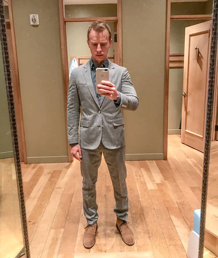 man trying on suit in fitting room