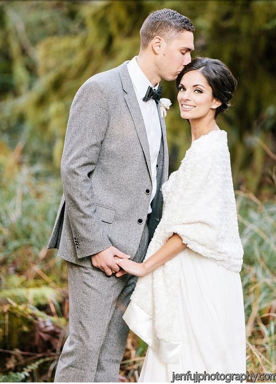 A man wearing a suit and tie next to a bride