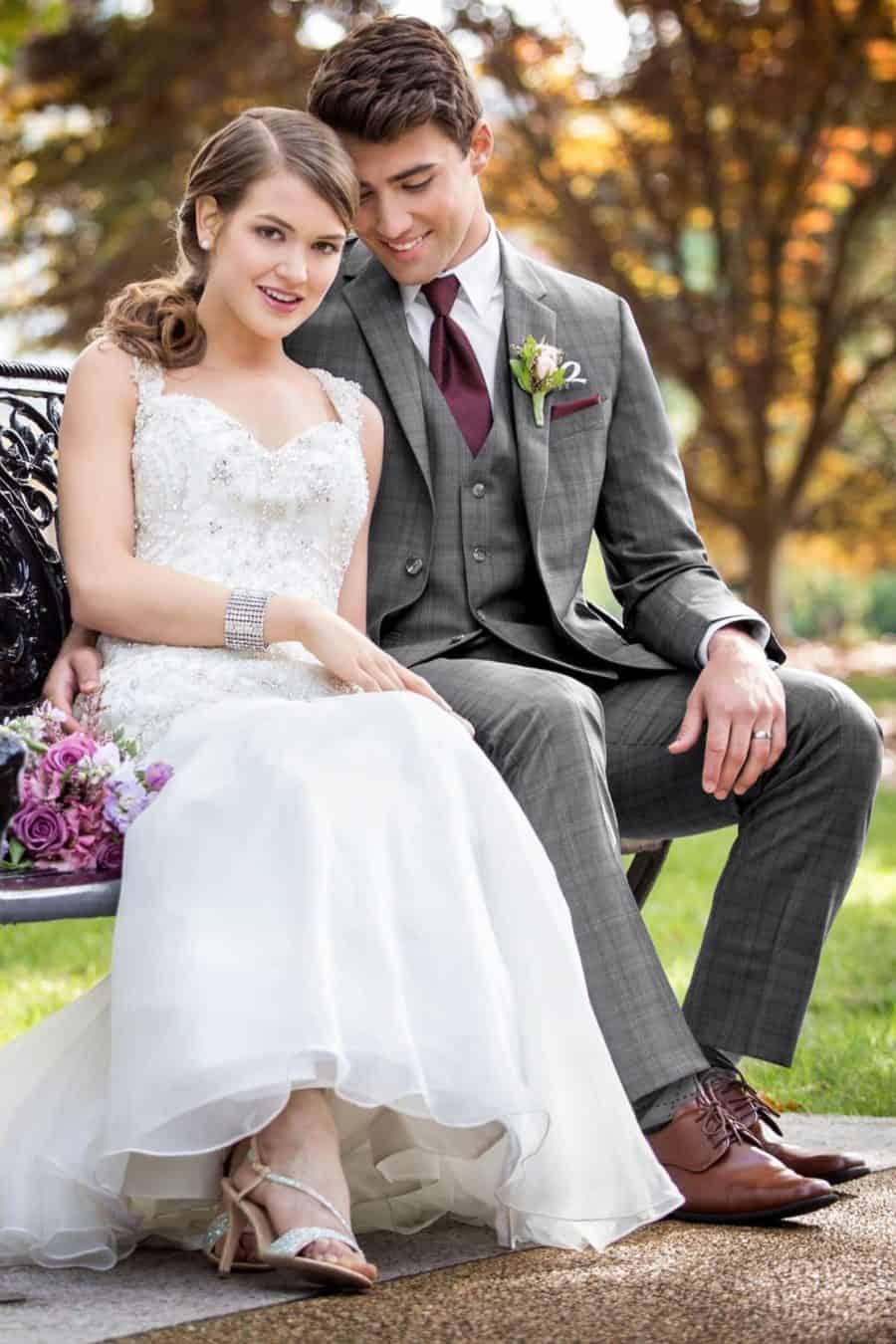 A wedding couple that are sitting on a bench