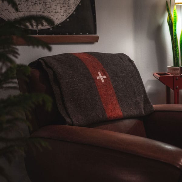 A living room with a military blanket and a chair