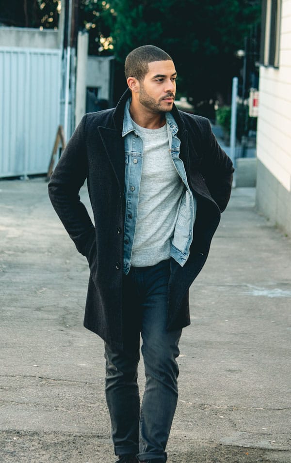 a men's style outfit with a topcoat layered over a denim jacket