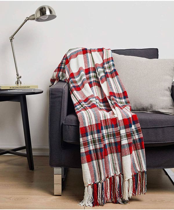 A bedroom with a blanket and a chair