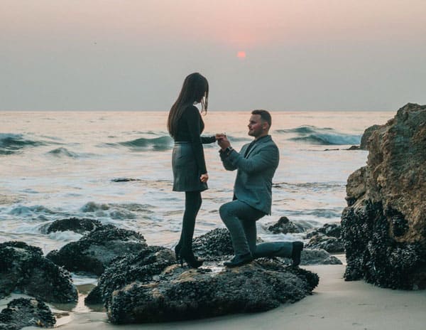 man proposing on the beach engaged