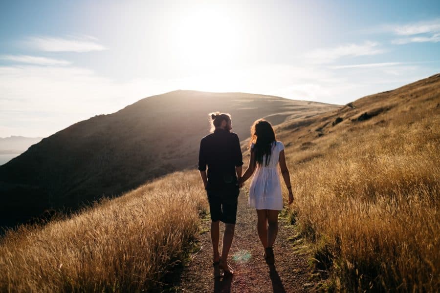 Image of couple walking hand in hand along a trail