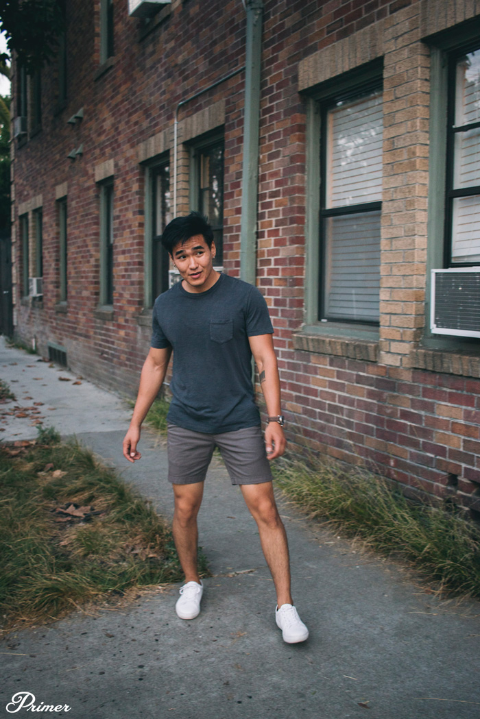 image of man wearing white sneaker shoes in summer with shorts and pocket t-shirt