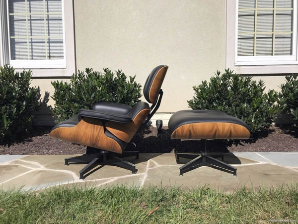 A brown leather chair and ottoman in front of a window