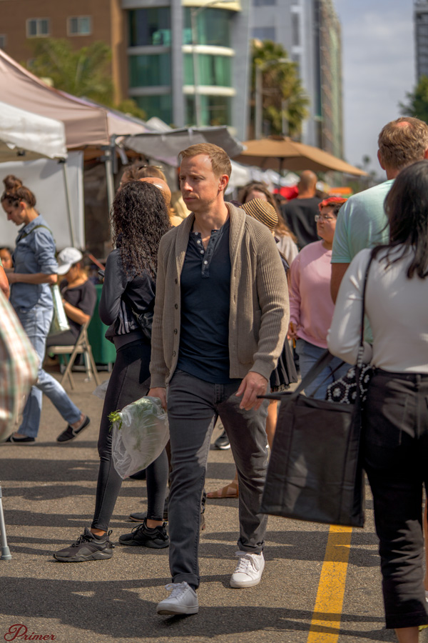 men's outfit idea with a tan shawl collar sweater, henley, gray jeans, and white sneakers