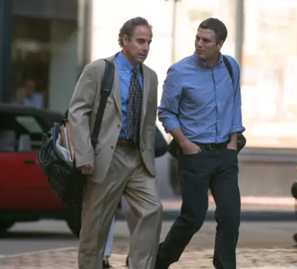 A man standing on a sidewalk, with Stanley Tucci