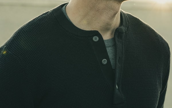 close up of the collar line of a black henley style shirt for primer magazine