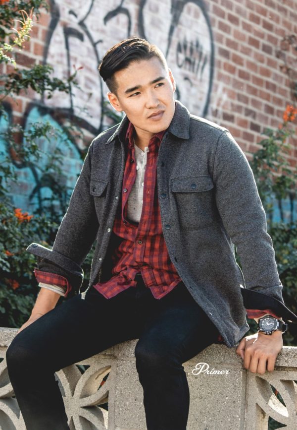 a man wearing a fleece shirt jacket over a long sleeve button up shirt, henley shirt, and slim fit pants