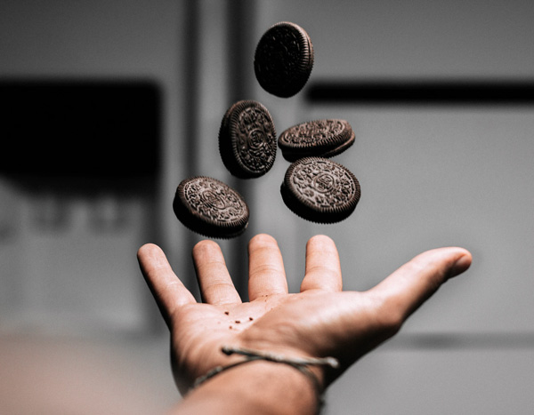 hand catching 5 oreo cookies