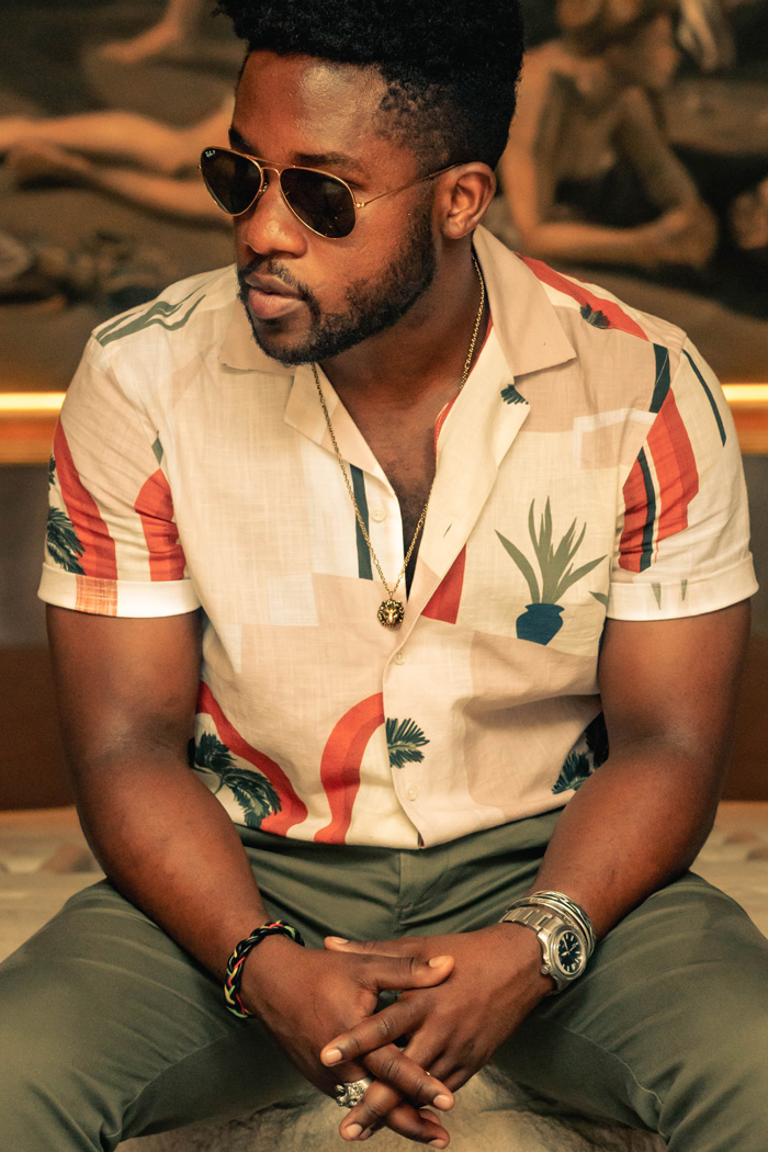 Daniel wearing necklace, bracelets, and rings man wearing camp collar shirt