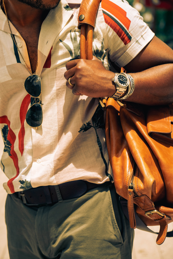 camp-collar-shirt_4 detail shot of camp collar shirt, sunglasses, watch, and weekender bag