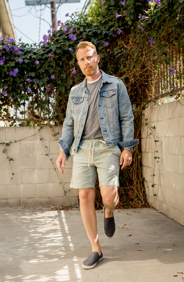 photo of man wearing seavees sneakers and denim jacket with shorts