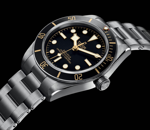 silver link watch with black and gold face