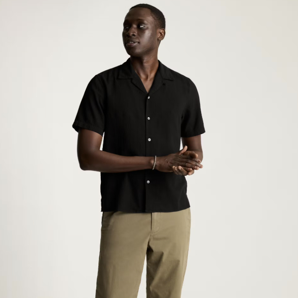 man wearing a short sleeve button front camp collar shirt with chino pants