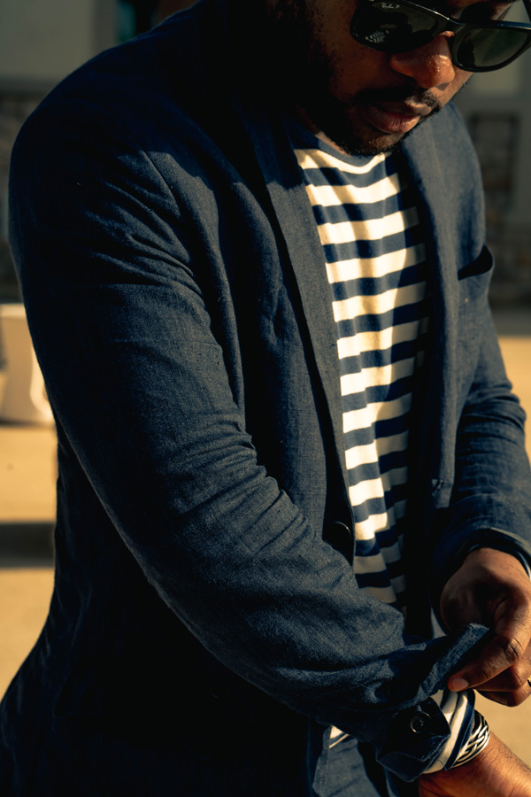 Daniel Baraka rolling the sleeves of his suit jacket