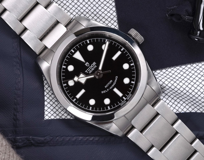 watch with silver link band and black and silver face