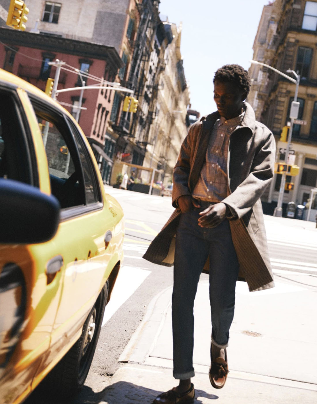 jcrew4 man standing on a sidewalk next to a yellow cab car