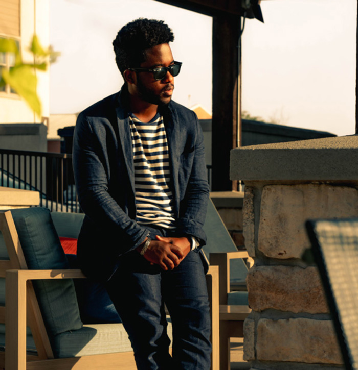 a man wearing a smart casual outfit of a suit set and striped shirt and sunglasses