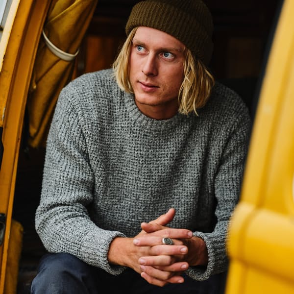 image of a man wearing a grey long sleeve sweater and a black beanie hat