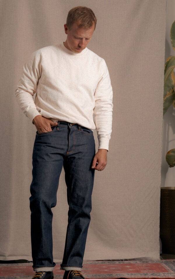 a man wearing denim jeans with a long sleeve shirt and boots