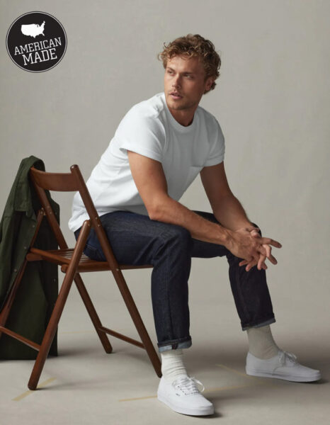 image of a man sitting in a chair wearing a white shirt and black pants